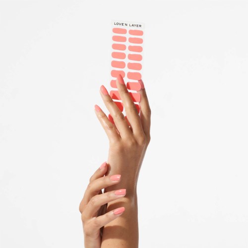 A hand holds a strip with many peach-colored layers, labeled "Love N Layer," on a white background.