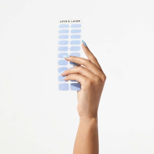 A hand holding a sheet with multiple light blue oval shapes and the text "LOVE'N LAYER" at the top.
