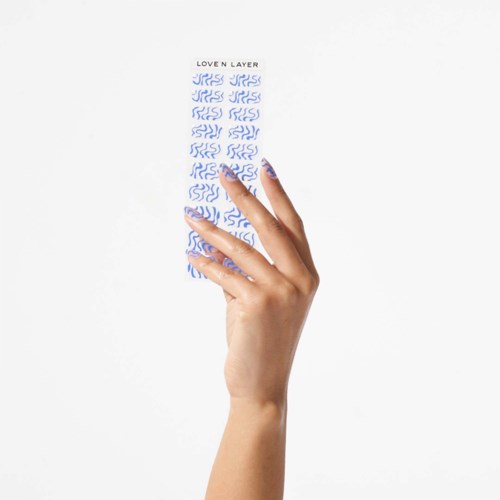A hand holds a strip of blue and white patterned stickers labeled "Loven Layer."
