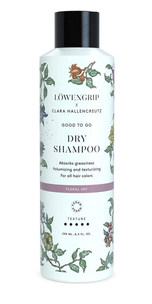 Eine weiße Flasche mit schwarzem Deckel, Blumenmuster und Etiketten für Trockenshampoo von Löwengrip und Clara Hallencreutz.
