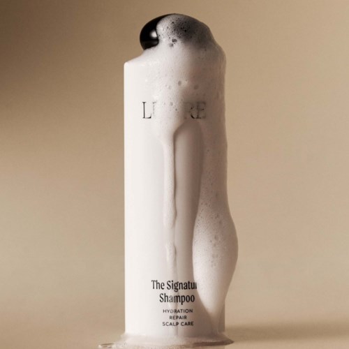 Eine Shampoo-Flasche mit Schaum, gekennzeichnet als 'The Signature Shampoo'.
