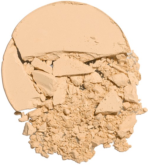 Een beige poeder met een grote stuk en kleinere stukjes, allemaal gebroken en uitgestrooid.