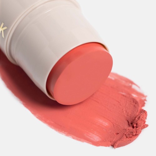 Een blok roze lippenstift met wat kleur uitgesmeerd op een witte achtergrond.