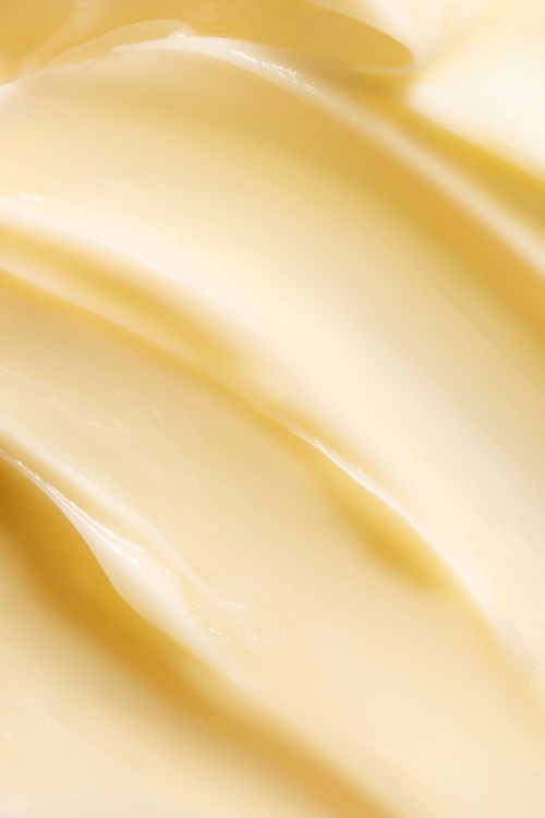 Een gladde, romige substantie met zachte, stromende golven, waarschijnlijk boter of margarine.