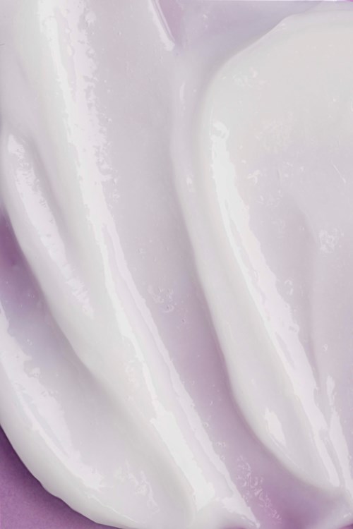 Een close-up van een witte romige substantie, mogelijk ijs of slagroom, met een gladde textuur en zachte draaivormen.