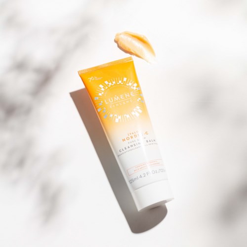Een tube Lumene huidverzorgingscrème ligt op een witte ondergrond met een kleine hoeveelheid crème ernaast.
