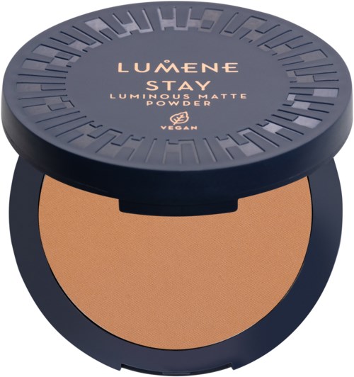Pyöreä meikkipuuterirasia, jossa on musta kansi ja kultainen teksti 'LUMENE STAY LUMINOUS MATTE POWDER', ja sisältää jauhetta.