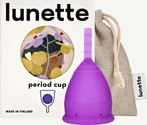 Eine feminine Tasse in Lila mit einem beige Stoffbeutel, Logo und einer farbenfrohen Illustration einer Frau mit Blumen.