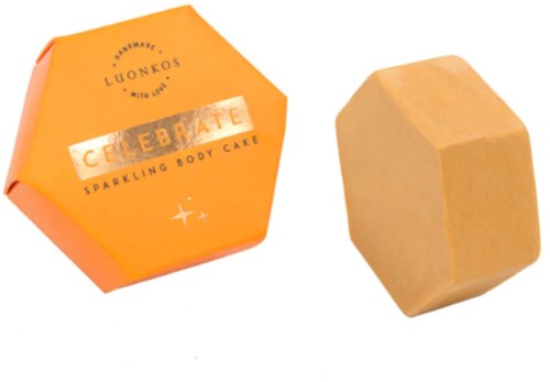 Ein Körperpeeling in orange Papier und ein beige rechteckiger Block, wahrscheinlich Seife.