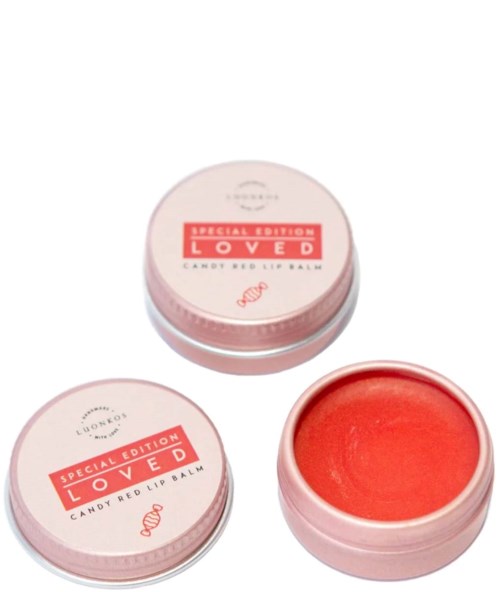 Runde rosa Dose mit rotem Lippenbalsam darin, gekennzeichnet 'Special Edition Loved Candy Red Lip Balm.'
