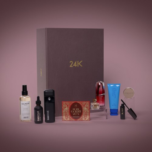 En samling av hudvårds- och skönhetsprodukter framför en stor grå box märk, '24K'.