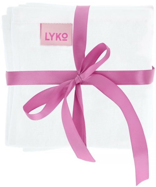 Ein weißer Stoff ist mit einem rosa Band gebunden, mit einem pinken Etikett mit der Aufschrift LYKO.