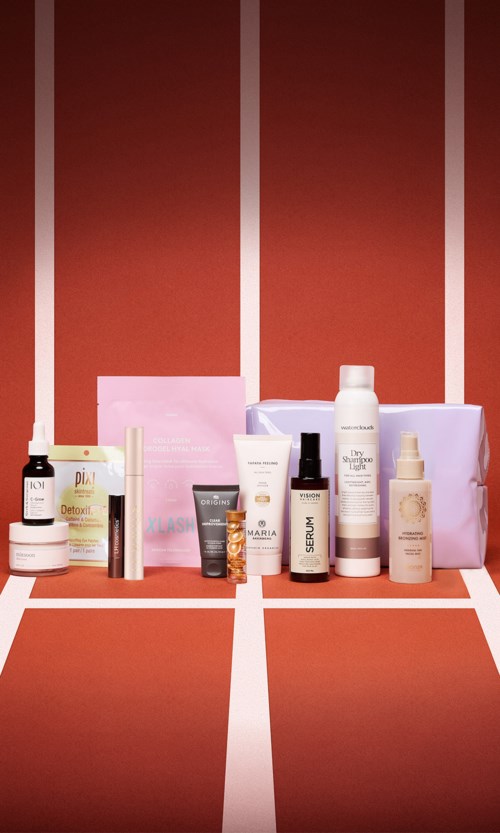 A collection of skincare products and gift boxes arranged on a red tennis court background.