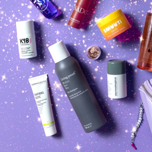 Beauty products, jars, bottles, and tubes arranged on purple and sparkly background.