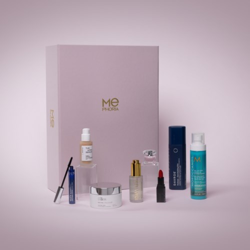 En samling hudvårdsprodukter inklusive krämer, serum och läppbalsam framför en rosa box.