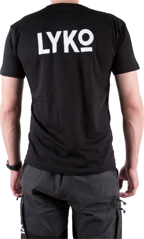 Eine Person trägt ein schwarzes T-Shirt mit großen weißen 'LYKO'-Schriftzug auf dem Rücken. Sie stehen mit hängenden Armen. Dunkle Hosen.