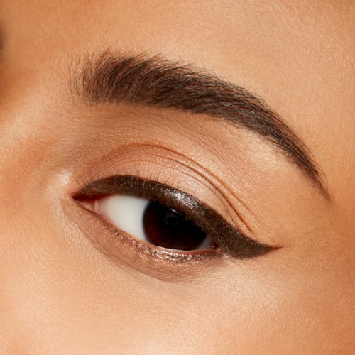 Nästa bild på ett kvinnligt öga med smink, inklusive svart eyeliner och brun ögonskugga.