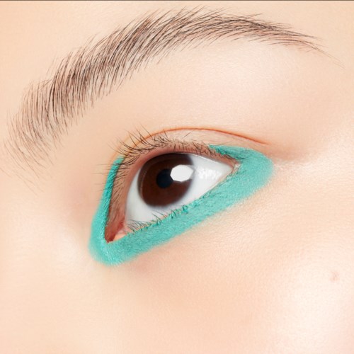 Närbild av ett öga med blå eyeliner på den nedre ögonlocket.