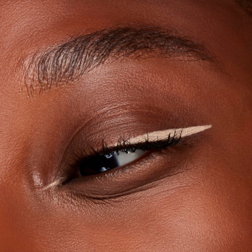 Close-up of an eye with makeup, including white eyeliner and natural skin tone.