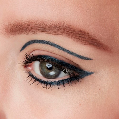 Close-up of a woman's eye with dramatic makeup, including eyeliner and eyeshadow in blue, and well-groomed eyebrow.