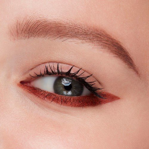 En närbild av en persons öga med välskött ögonbryn och makeup på ögonlocket och nedre franslinjen.