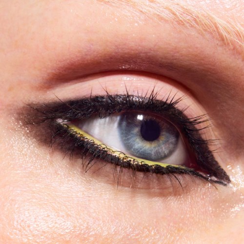 Close-up of a blue eye with makeup, including eyeliner and eyeshadow, showcasing detailed eyelashes and skin texture.