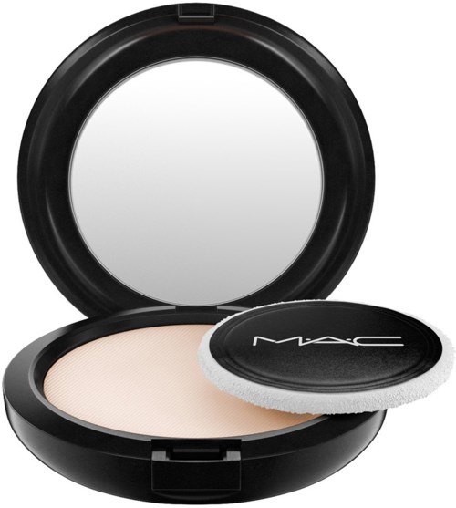 A compact powder container with mirror, sponge applicator, and beige powder inside.