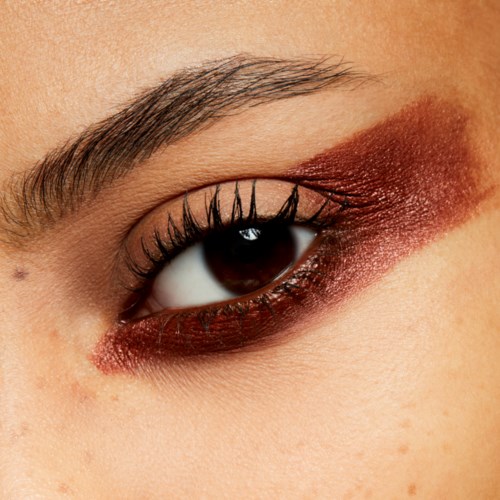 Eine Nahaufnahme eines Auges mit Make-up, inklusive Eyeliner, Lidschatten und langen Wimpern.