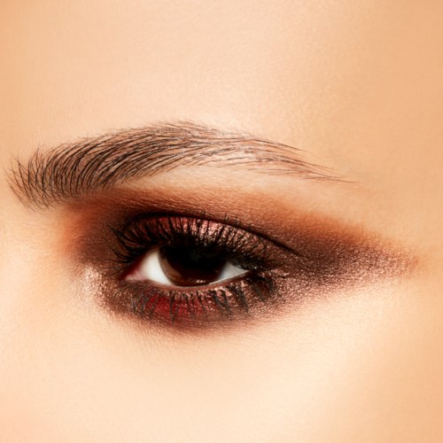 Nahaufnahme eines weiblichen Auges mit Makeup, inklusive Lidschatten und Augenbrauenstyling.