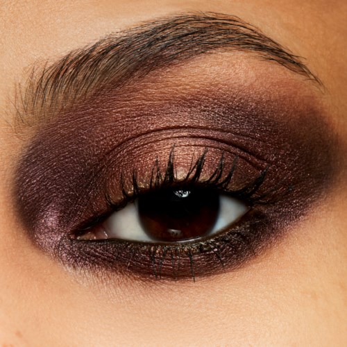Nahaufnahme eines Auges mit dunklem Make-up, langen Wimpern und gepflegter Augenbraue.
