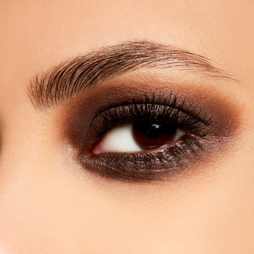 Nahaufnahme eines Auges mit Make-up, einschließlich Lidschatte, Eyeliner und Mascara, und gepflegte Augenbraue.