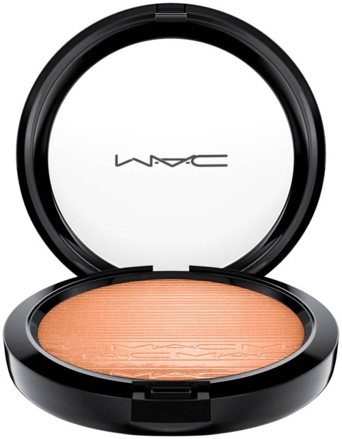An open makeup compact with a black case, containing peach-colored powder. The brand MAC is visible inside the lid.