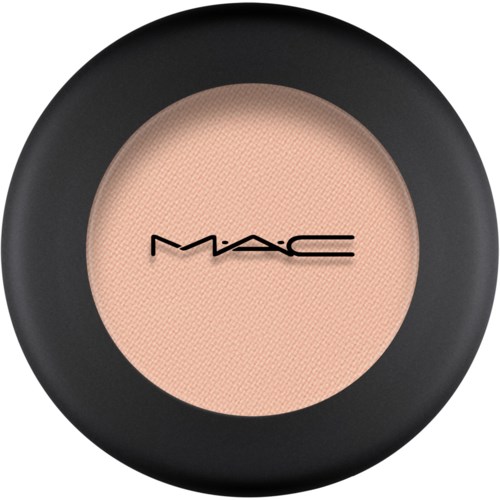 A round container with makeup or powder inside, labeled 'MAC'. The container is black on the outside.