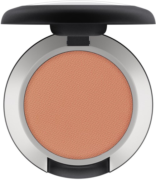 A round makeup compact with orange blush inside and a black lid on top.