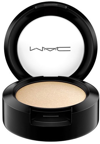 A round black container holds beige powder, with the lid open revealing the MAC logo on top.