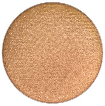 A round, golden-brown makeup product, likely eyeshadow, with a shimmery, smooth surface.