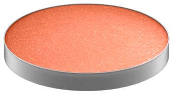 A round orange makeup blush or powder in a silver container.