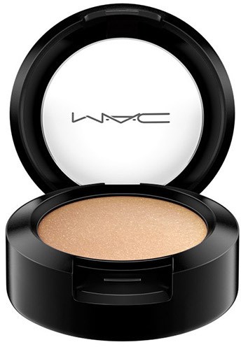 A round black makeup compact with shimmery beige powder inside and a lid that has the MAC logo.