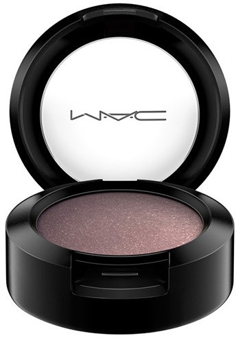 A round black makeup compact with pinkish powder inside and a mirror on the lid, showing MAC logo.