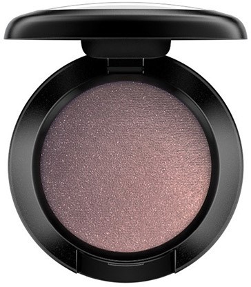 A compact round makeup case with light pink shimmery eyeshadow inside.