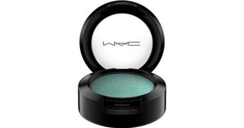 A teal eyeshadow inside a black round makeup container with the MAC logo on the lid.