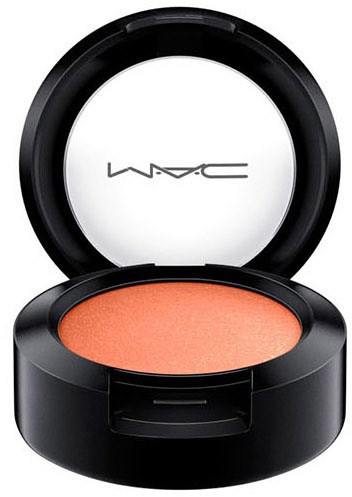 A round compact with orange face powder inside and MAC logo on the inside of the lid.