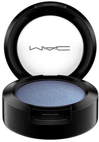 A black round makeup compact with blue shimmering eyeshadow inside and MAC logo on the lid.