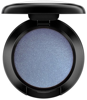 A round, black makeup compact with a shimmery blue eyeshadow inside and a lid open.