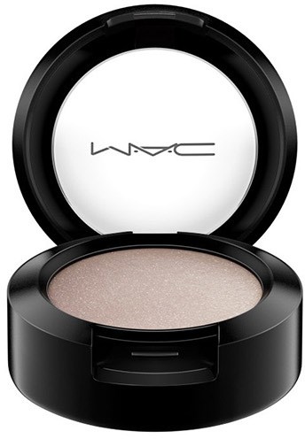 A makeup compact with a shiny, light-colored eye shadow inside, and a black outer case. The lid is open.