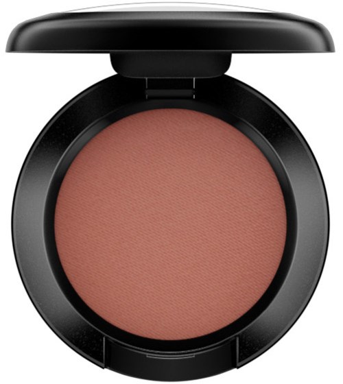 A round makeup blush in a black compact with a cover open, showing soft pink color inside.