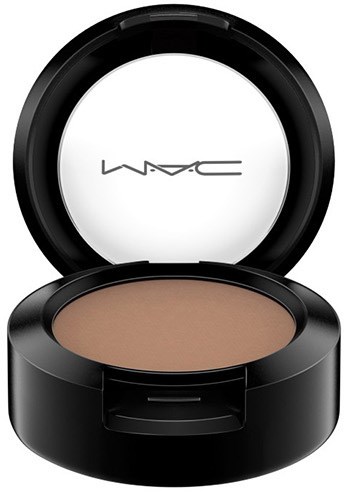 A round makeup compact with beige powder inside and a black lid with the MAC logo. It is open.