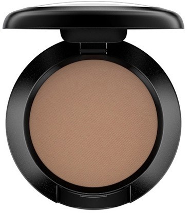 A compact with a large round beige makeup shadow inside and a black lid.