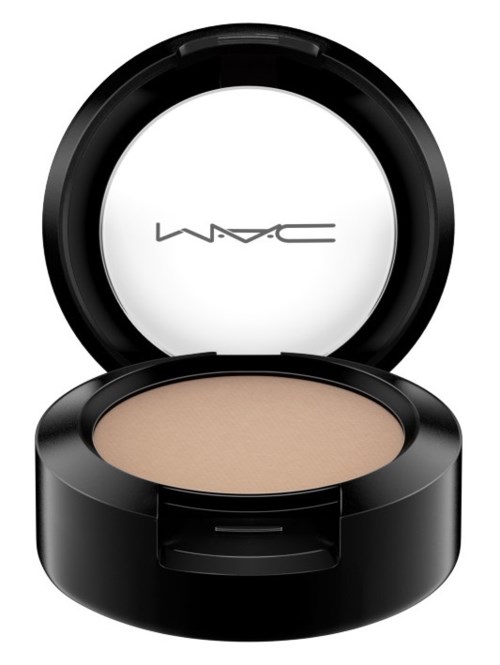 A round black makeup compact with beige powder inside, open lid shows MAC logo on the mirror.