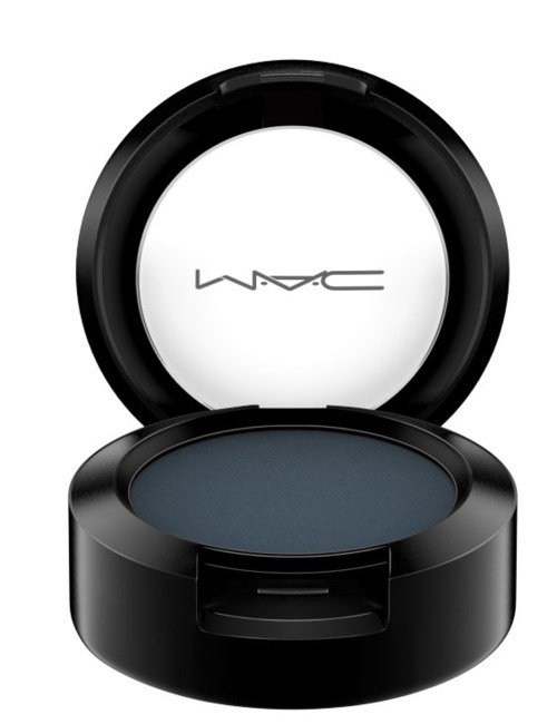 En svart rund makeup-compacta med blå ögonskugga inuti och en vit M·A·C-logga på innanför locket.
